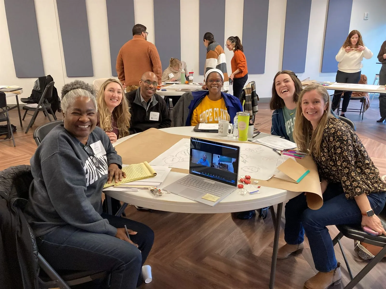 Workshop participants gathered around a table, smiling and learning together